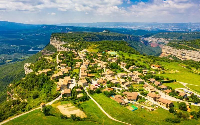 A panoramic view of a village, its houses scattered on a green valley