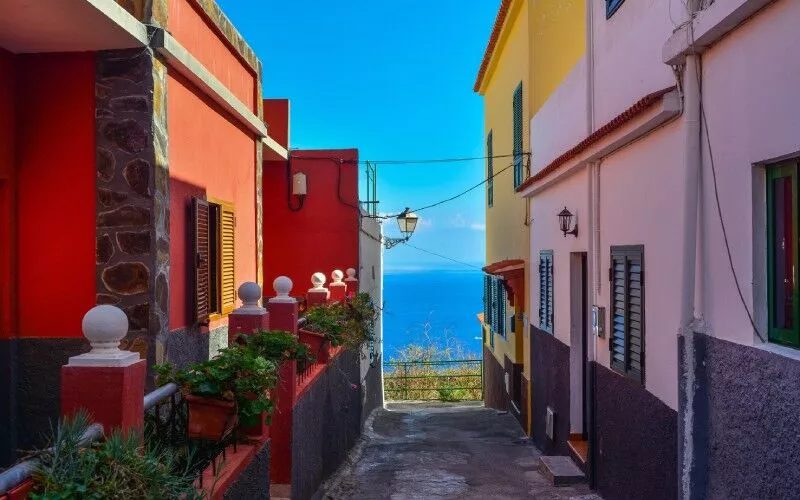 A colourful street and the sea on the background